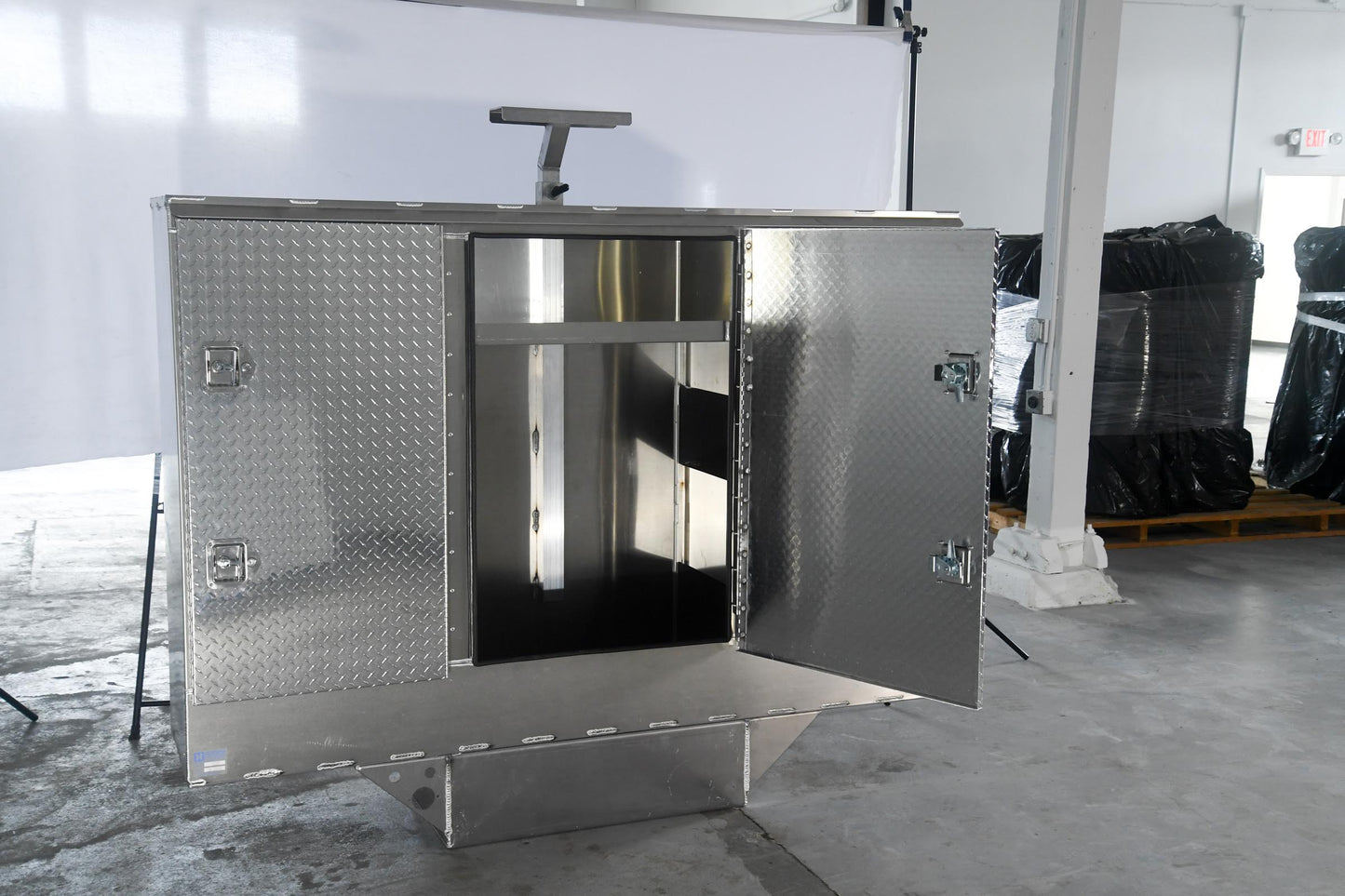 Metal storage cabinet with open door in a warehouse setting